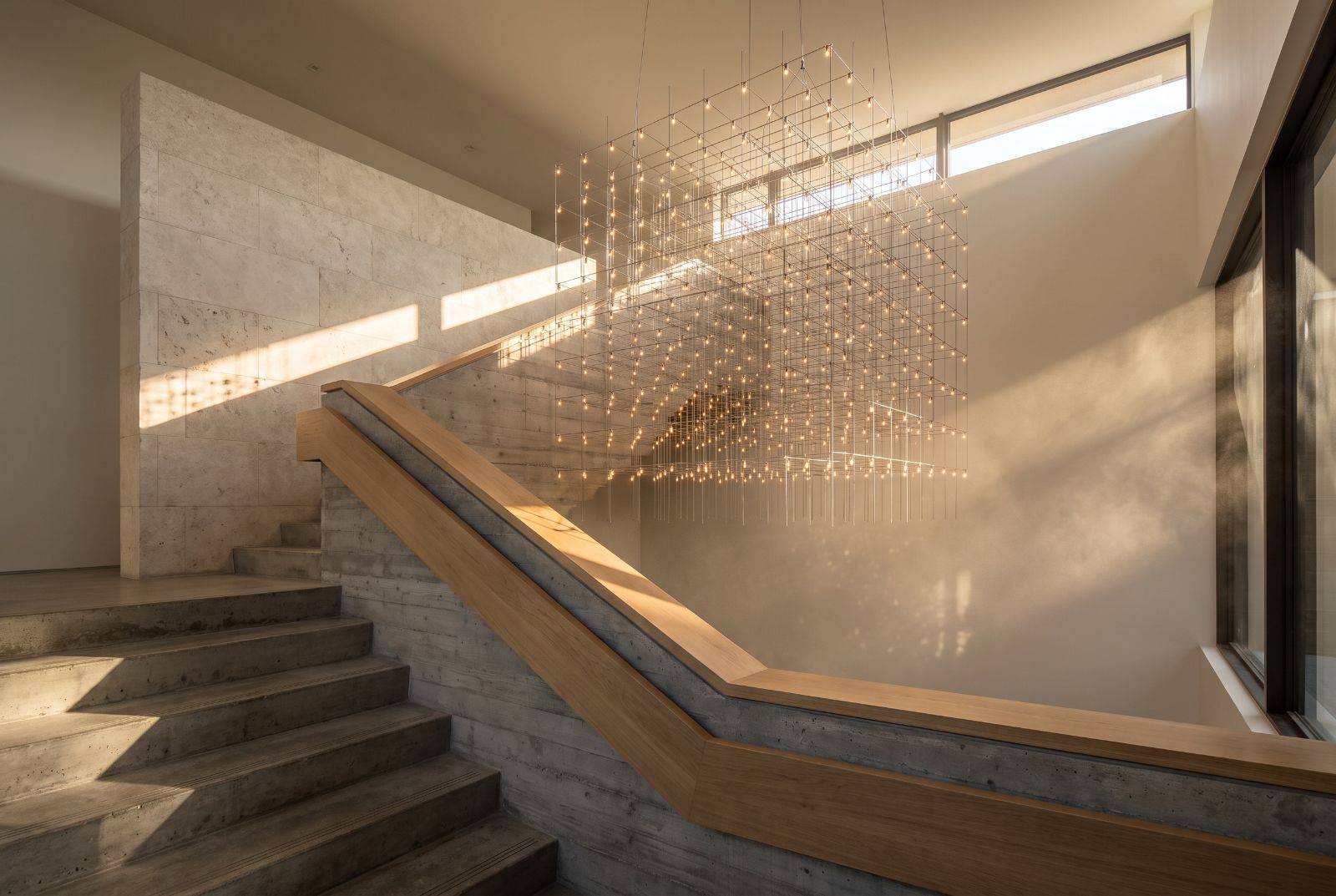 Molecule Cube pendant above a luxury stairwell in golden afternoon light